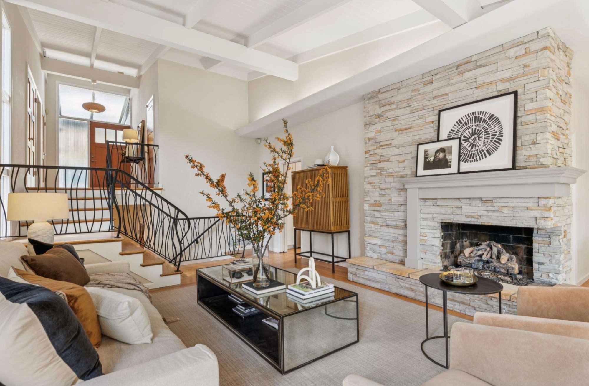 1297 Sunnyhills Road — Great room with stone fireplace, beamed ceiling, and wall of glass to the deck